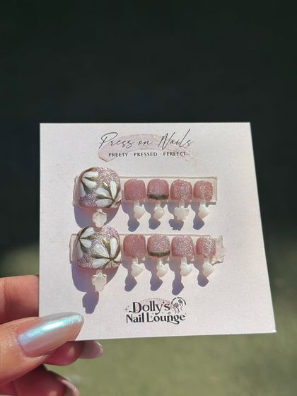 This press-on toe nail set features delicate, hand-painted floral art on the big toe, paired with shimmery pink on the others.