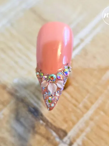 This glamorous design with a cascade of rhinestones and 3D shell accents was done by a student. They learn proper stone placement to ensure the design is not only beautiful but also durable.