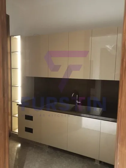 This image showcases the secondary wet area of the kitchen, complete with a built-in sink and backlit open shelving. The handleless, high-gloss cabinets contribute to the clean, modern design.