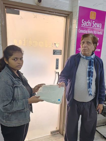 An elderly man receives warm innerwear from our team. We aim to provide practical and essential items to those in need.