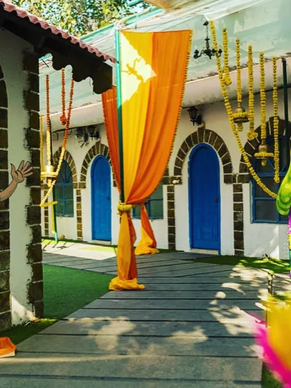 Cartoon cutouts and marigold garlands create a fun and welcoming entrance for a Mehendi ceremony.