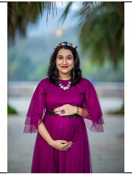 A joyful, direct-to-camera portrait of a mom-to-be, her happiness shining through.