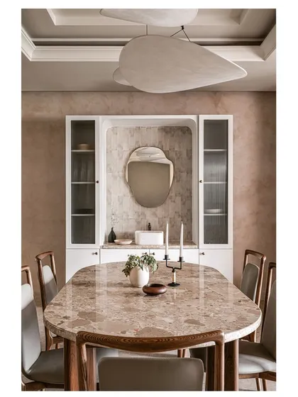 The dining room in Project ASA is a statement in itself. It features a custom dining table with a stunning inlay stone top, a unique sculptural ceiling light, and a built-in crockery unit with a textured tile backsplash.