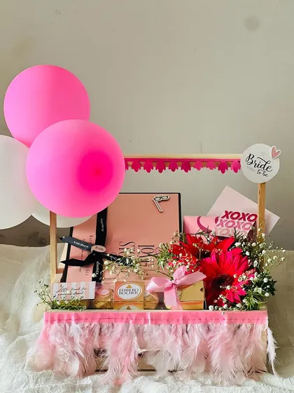 Celebrating the bride-to-be with a fun and festive hamper. This arrangement includes balloons, fresh flowers, and a collection of pink-themed gifts, all designed to make her feel special before the big day.