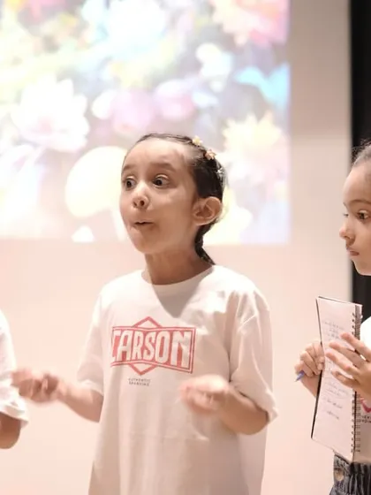 A young actor passionately delivering her lines during a 'Mission Unstoppable' rehearsal. This captures the development of vocal projection and expressive communication skills.