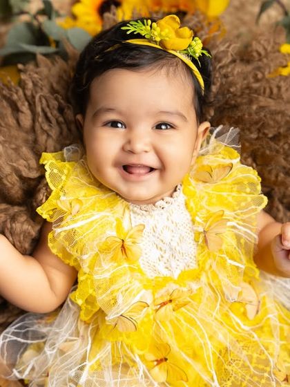 A perfect three-month milestone photo. This baby girl's happy smile, captured in a basket surrounded by sunflowers, is a beautiful memory of this fleeting stage.
