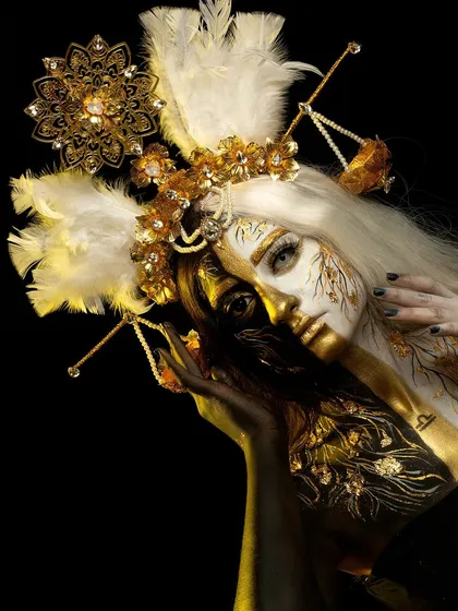 A full view of the Libra-themed fantasy makeup. This avant-garde look uses gold and white body paint, custom headpieces, and delicate details to represent balance and celestial beauty.
