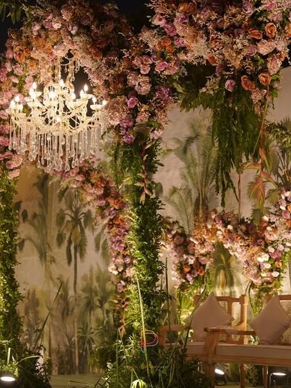 The elegant seating placed before the romantic floral arch backdrop, ready for the couple to make their appearance.