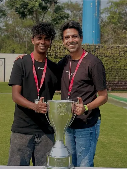 Our coach with the Reliance Foundation U15 girls championship trophy, showcasing our success at the youth level.
