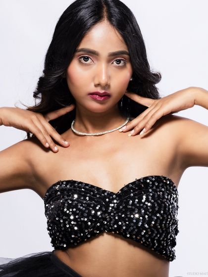 A close-up of the model in a sequined top, with a confident expression.