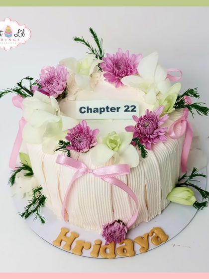 "Chapter 22" begins with this dreamy and elegant birthday cake. It's adorned with a crown of fresh pink and white flowers and delicate ribbon details.