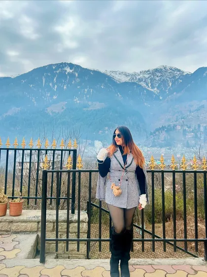 A full-length shot of my winter look in Manali. The snow-capped mountains provide the perfect backdrop for this stylish outfit.