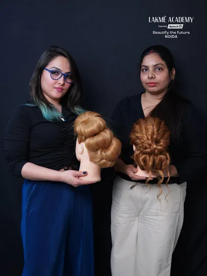 Students presenting their classic and voluminous bun hairstyles, a core skill for any professional hairstylist.