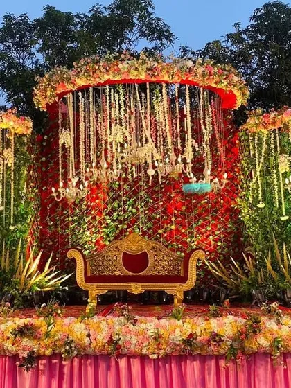 The same romantic greenery stage seen at night, with the lighting creating a warm and magical ambiance.