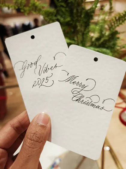 "Merry Christmas" and "Good Vibes 2025." Simple, elegant handwritten tags created during a live event, perfect for adding a personal touch to holiday gifts.