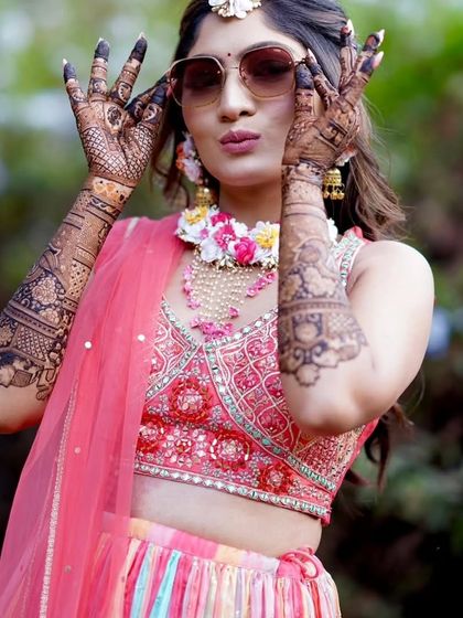 A cool bride with sunglasses, showing off her intricate mehandi. A fun and modern take on the traditional mehandi pose.