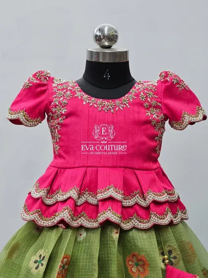 A detailed shot of a pink peplum blouse. You can see the delicate gold embroidery on the neckline and sleeves, and the scalloped layers of the peplum.