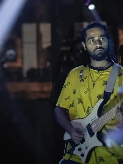 Our guitarist, caught in a beam of light, completely focused on the music. We bring this level of professional musicianship and passion to every live pub performance.