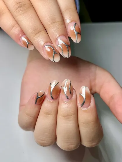 Shining bright with new chrome nails. This design features a brown ombré base with delicate silver chrome swirls for a sophisticated and modern look.