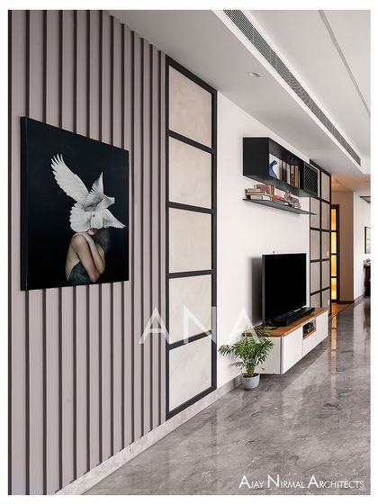 This view highlights the long, continuous line of sight in Apartment 704's living area. The minimalist TV wall with fluted panels and strategic art placement creates a sophisticated and uncluttered environment.