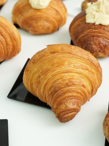 A perfectly laminated croissant, showcasing the crisp, golden layers that are the hallmark of excellent viennoiserie.