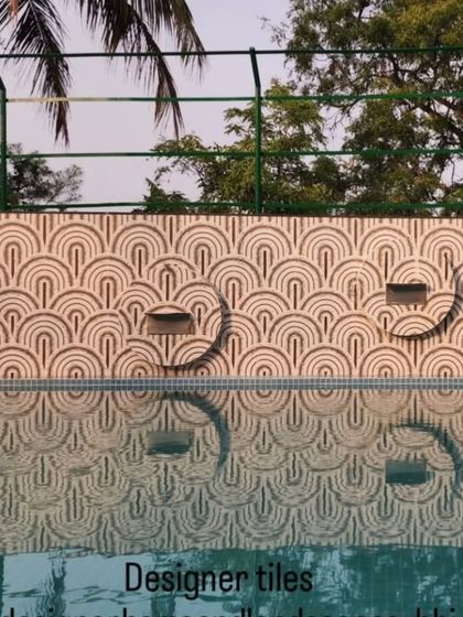 Designer tiles used for a poolside wall. The art-deco pattern creates beautiful reflections in the water, adding another layer of design to the space.