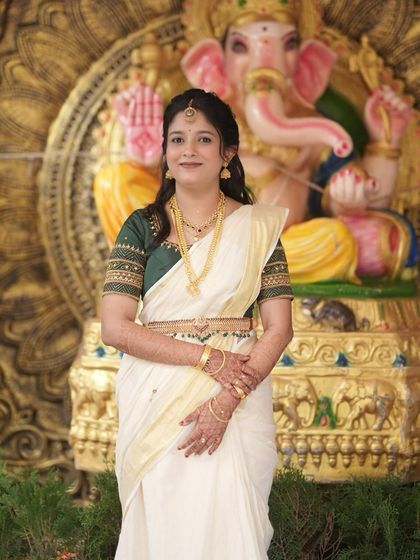 This image captures the beautiful simplicity of a traditional South Indian bridal style. The makeup is subtle, allowing the bride's natural beauty and the elegance of her saree to shine through.