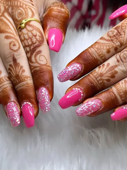Perfect for a bride or any special occasion, this manicure pairs bright pink nails with full-coverage silver glitter accent nails. The look is further enhanced by tiny rhinestones at the cuticle line.