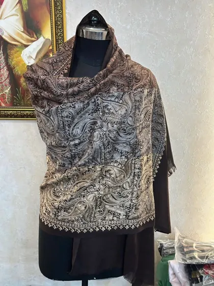 A close up of the brown and silver paisley pashmina. You can see the fine details of the embroidery along the border.
