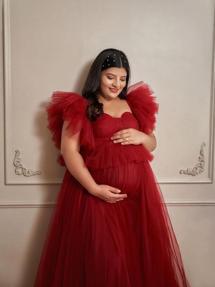A close-up of our dark red Lorna gown. The layered ruffles on the off-shoulder neckline add a touch of high-fashion drama.