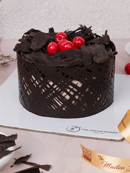 My take on the timeless Black Forest cake. It has layers of chocolate cake, whipped cream, and cherries, all wrapped in a modern chocolate lattice and topped with more chocolate shavings.