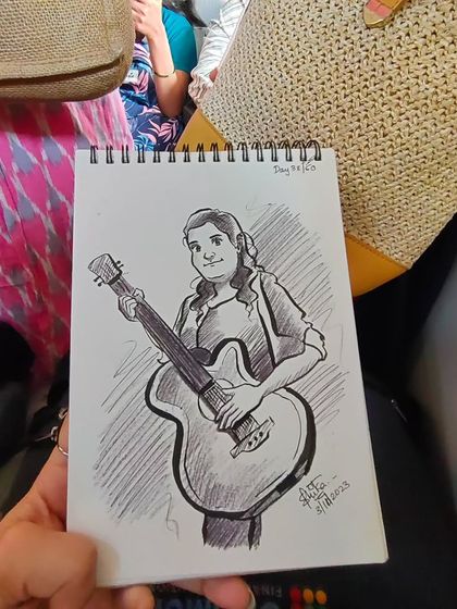 Another angle of the guitarist caricature, showing it held in hand to give a sense of its size.
