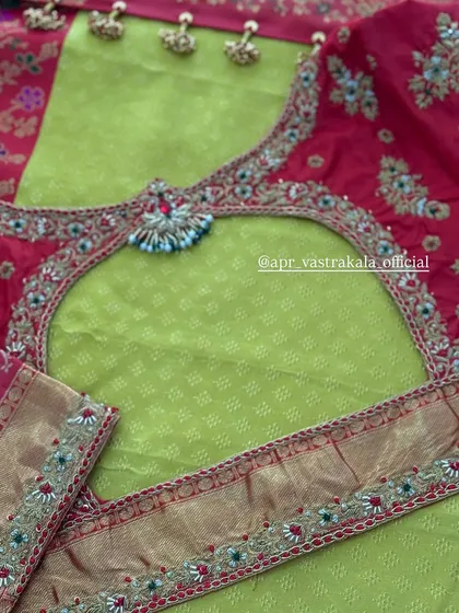 A U-shaped back cutout on a pink blouse, framed with a heavy border of traditional embroidery and paired with a lime green saree.