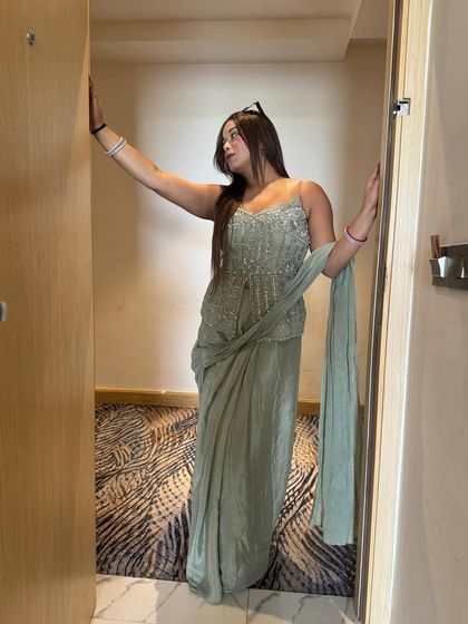 Another look at this elegant sage green ensemble. The intricate beadwork and flowing fabric make it a standout piece for any wedding event.