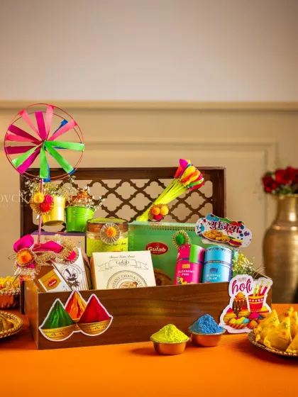 A wooden crate Holi hamper, styled with bright colors and festive elements for a modern yet traditional feel.