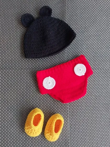 Bring the magic of Disney to your baby's photoshoot with this classic Mickey Mouse inspired outfit. The set includes the iconic ears hat, red shorts with buttons, and tiny yellow booties, all handcrafted by me for a perfect fit.