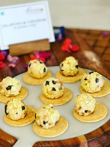 Jalapeño and cheddar cheese bites served on mathri crackers, a perfect fusion of spicy, cheesy, and crunchy.