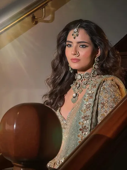 A striking portrait of the bride on a staircase. The lighting creates a dramatic effect, highlighting her powerful and elegant look.