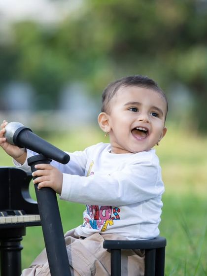 This future musician is enjoying an outdoor concert, with a mini piano and microphone set up in the park.