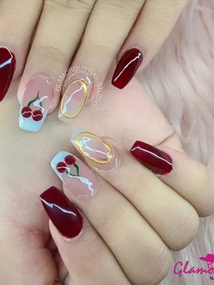 A sweet and juicy design. This set combines classic, glossy red nails with accent nails featuring hand-painted cherries and a modern, 3D gold-wire accent. It's a fun and fruity look.