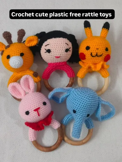 I make these cute and colorful rattle toys for newborn babies. They are designed for tiny hands to hold, with different animal heads like a giraffe, bunny, and elephant. They are perfect, safe gifts for baby showers.