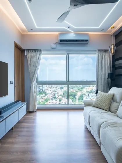 The floating TV console in this room maintains the clean, modern aesthetic, while floor-to-ceiling windows frame the cityscape and fill the room with natural light.