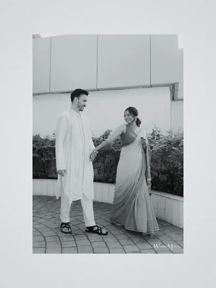 A candid black and white photo of the couple walking together, sharing a smile. This simple, happy moment is what makes wedding photography so special.