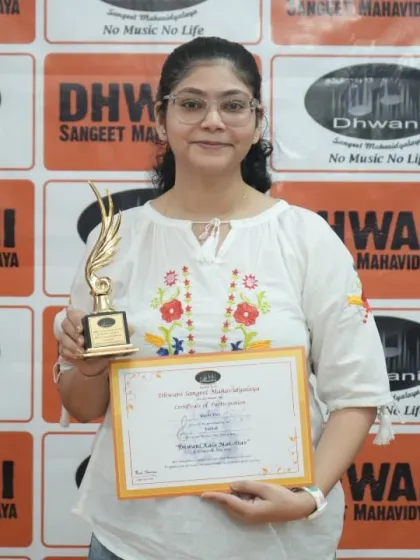 An adult student proudly displays her certificate and award.