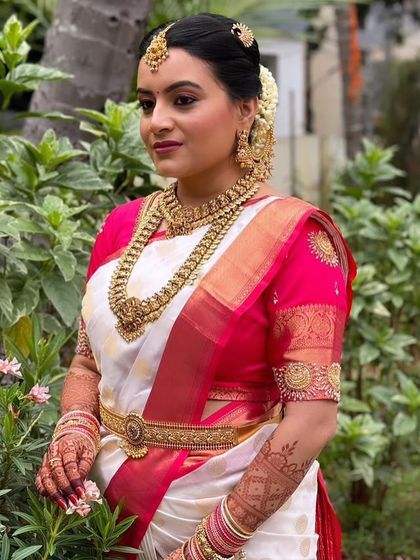 A full view of Sahana's stunning bridal attire. The layered necklaces and the perfectly matching vaddanam (waist belt) create a cohesive and regal look that we were so happy to help create.