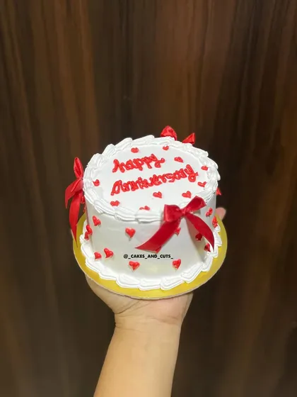 A fun anniversary bento cake with red ribbons and hearts.