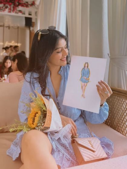 Holding a sketch of my outfit. I love it when art imitates life. This blue dress is truly a piece of art.