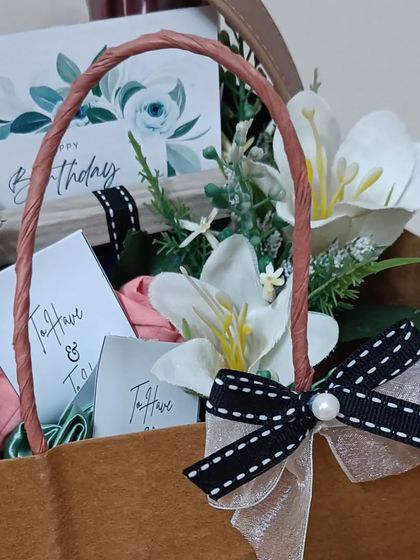 A detail shot of the matching brown paper bag, decorated with a black and white ribbon.