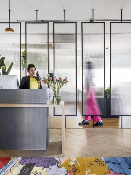 The reception area for LWYD Interactive, designed to make a strong first impression. We used fluted glass panels to create a sense of openness while maintaining privacy, balancing a modern aesthetic with a welcoming, human touch.