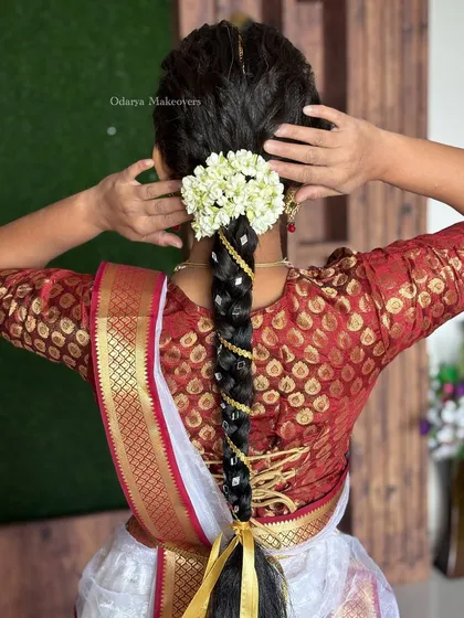 A beautiful traditional hairstyle for a client dressed as Radha for her kids' school performance. The braid is adorned with fresh flowers and gold ribbon.